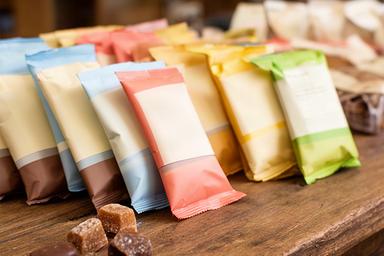 Individually packed gluten-free sweets and chocolate snacks displayed on a wooden counter