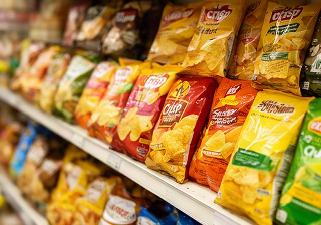 Crisp multipacks displayed on a shop shelf beside savoury snack packets