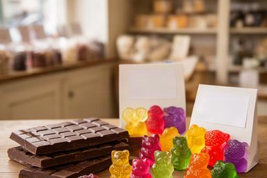 Vegan chocolate bars and colourful gummy sweets arranged beside dietary labels in a Stranraer sweet shop